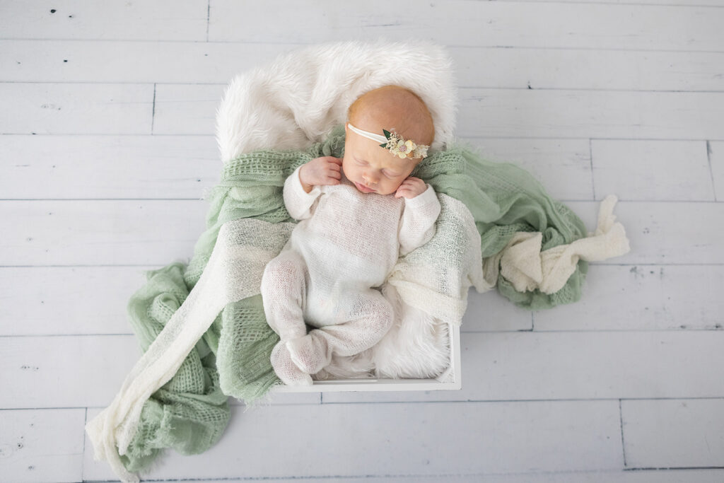 baby girl in white onesie sleeping in a box, pukekohe newborn shoots